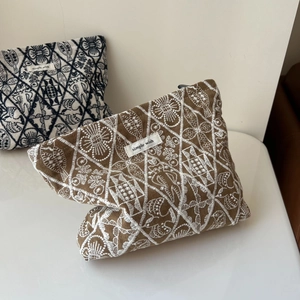 Detailed embroidery on a brown linen organizer bag featuring intricate floral patterns