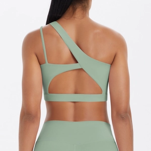 Detail of mint green sports bra featuring an asymmetric strap design and open back style