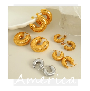 Close-up of assorted 18K gold and silver plated chunky textured hoop earrings on a tray