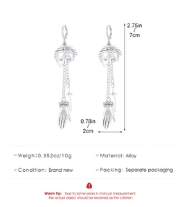 Macro view of vintage silver skeleton earrings with exact size measurements in inches