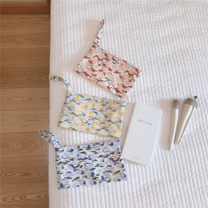 Detailed close-up of three floral cotton storage bags in red, yellow, and purple floral prints