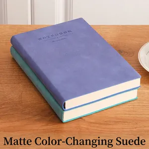 Stack of purple and cyan nubuck leather A4 notebooks on a light wood surface