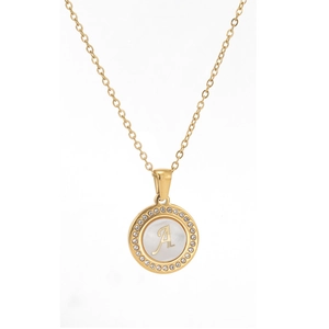 Close-up of golden necklace pendant with shell inlay, crystal border and cursive letter A