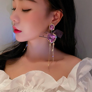 Detail of purple crystal heart earrings with black mesh bow and long chain tassels