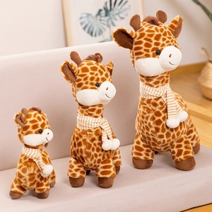 Three plush giraffes in varying sizes with striped scarves on a cozy white sofa