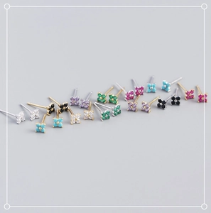 Macro view of tiny S925 sterling silver four-leaf flower studs with colorful zircons