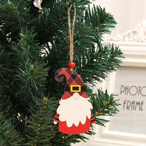 Detailansicht eines hölzernen Weihnachtswichtels, der an einem grünen Tannenzweig hängt.