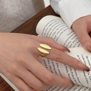 Close-up of minimalist gold open ring with organic shape on model hand