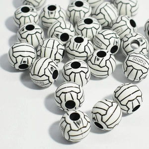 Detailed view of white acrylic soccer ball beads with central hole for jewelry making