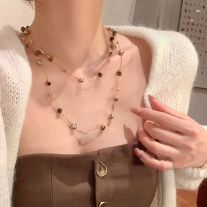 Détail d'un collier double rang plaqué or 18k avec pierres œil de tigre et perles