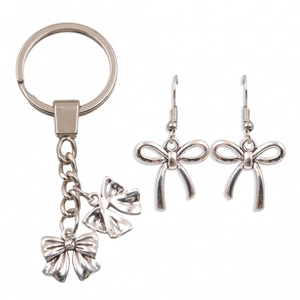 Silver bow alloy jewelry set with keychain and hook earrings on a white background
