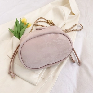 Pink suede-textured bucket bag with gold chain strap and drawstring closure