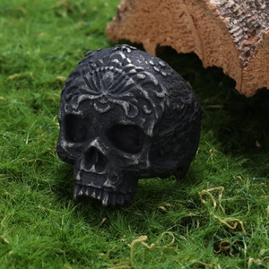 Macro shot of vintage skull ring with intricate floral carvings on a rustic wooden background
