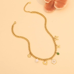 Detailed flat lay of golden Cuban chain necklace with pearl heart and flower charms