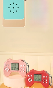 Close-up of pink mini handheld game console back showing speaker and LR44 battery slot
