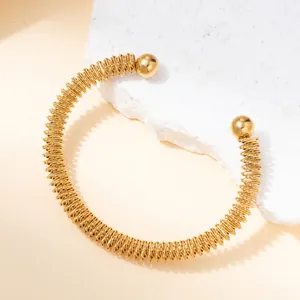 Detailed macro view of 18k gold plated titanium steel spiral bracelet on stone background