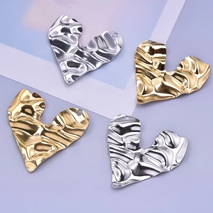Detail of vintage heart pendants with irregular pleated texture in gold and silver steel