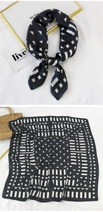Detail of geometric black and white silk scarf with luxury smooth texture and pattern