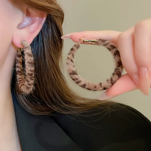 Vue détaillée de grandes créoles à imprimé léopard avec une texture en peluche douce