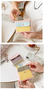 Detail of macaron-colored PU leather mini wallet with button closure and card slots