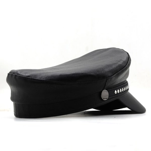 Detail of black leather newsboy cap showing silver metal rivets and textured stitching