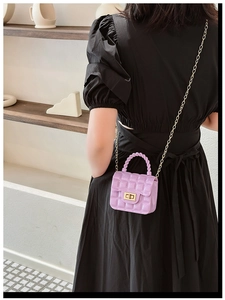 Detail of purple quilted jelly bag with gold chain strap and metal twist lock on model
