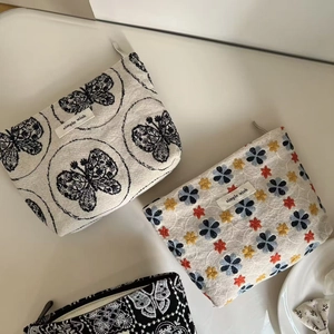 Detailed shot of embroidered canvas pouches with floral patterns and a simple wish label