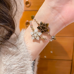 Close-up of star-shaped tiger eye and crystal beaded bracelets with woven rope
