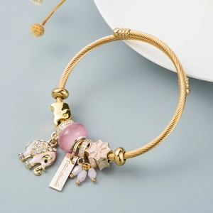 Adjustable gold spiral bracelet with pink enamel elephant charm and Dream More tag