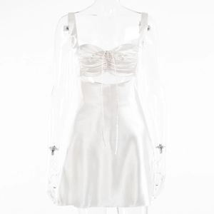 Detailed close-up of white satin mini dress with drawstring ruched bust and cutout detail