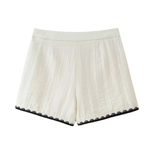 Detail of off-white crinkled texture fabric shorts with black wavy embroidery trim