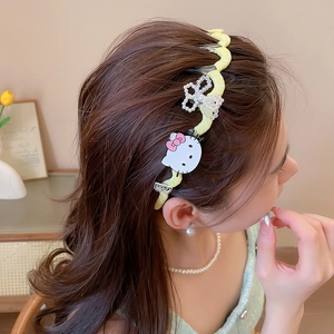Detail view of yellow wave pattern headband with Hello Kitty character and floral pearl charm