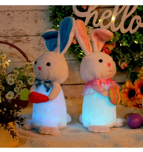 Close-up of glowing plush Easter bunnies with carrot and colorful egg holiday decorations