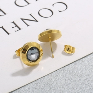 Macro shot of French style gold round stud earrings with grey faceted crystal inlay