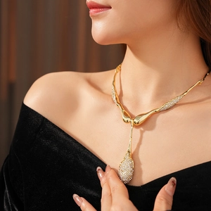 Gros plan du collier goutte d'or avec cristaux scintillants sur le cou du mannequin