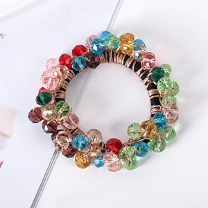Close-up of colorful faceted crystal beads on an elastic hair tie with golden threads