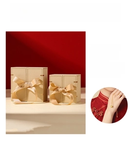 Detail of luxury beige jewelry boxes with golden ribbons and elegant red interior lining