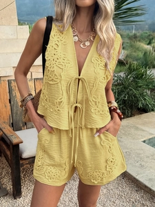 Detail of yellow sleeveless V-neck vest and shorts set with fine floral embroidery