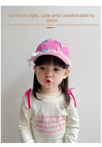 Pink toddler baseball cap with white lace ruffles and colorful bows on model
