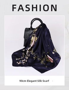 Detail of 90cm floral silk scarf draped on a luxury black leather handbag