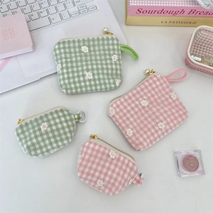 Detailed view of floral gingham pouches with pearl zippers and lace embroidery