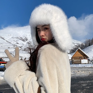 Detail of white faux fur trapper hat with ear flaps in a snowy mountain setting