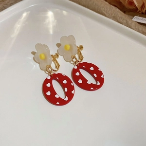 Detail von Gänseblümchen-Ohrringen mit roten Herzanhängern und Schraubclips