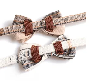Close-up of grey and beige plaid pet bow ties with elastic straps for collars