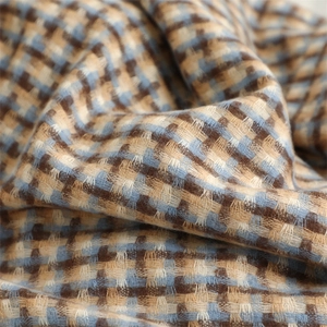 Macro view of blue and brown plaid fabric texture showing soft thick knit material