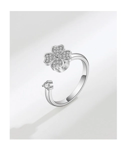 Detailed macro view of rotating four-leaf clover ring with zircon stones in silver