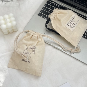 Minimalist canvas drawstring bags for cosmetics shown with laptop and candle