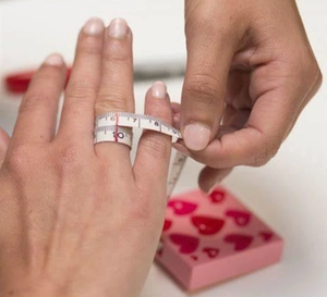 Messen des Fingerumfangs mit einem flexiblen Maßband zur Bestimmung der Ringgröße