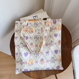 Détail d'un sac cabas en coton avec motifs floraux et ours sur une table en bois