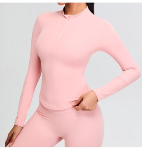 Detailed close-up of pink long-sleeve half-zip yoga top and high-waisted leggings set